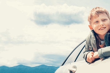 Young child enjoying scenic drive in family car