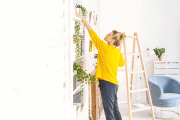 Woman decorating and adding plants to her new home as a first home buyer