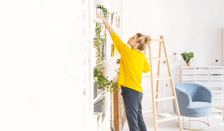 Woman decorating and adding plants to her new home as a first home buyer